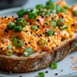 Gochujang eggs creamy spicy Korean breakfast served on toasted sourdough bread with sesame seeds and green onions