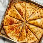 sheet pan quesadillas with ground beef and melted cheese golden brown and crispy on baking sheet showing folded tortilla edges ready to serve 8 people