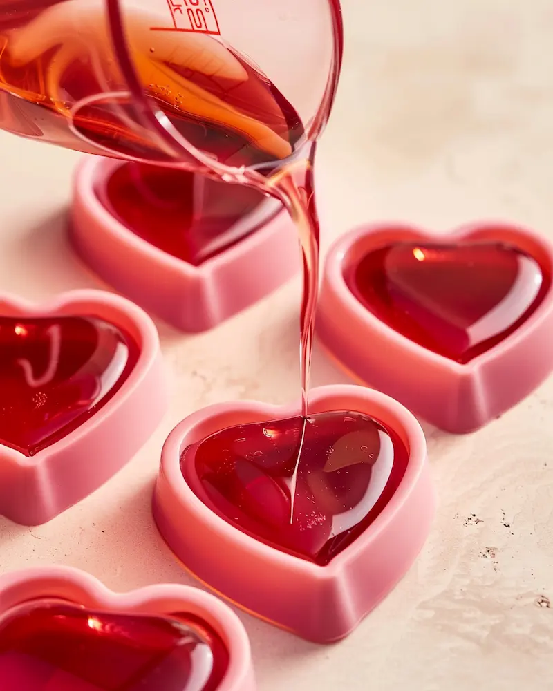 rebel wilson weight loss gelatin recipe being poured into heart shaped silicone molds for portion control