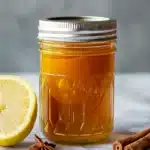 Sealed glass jar of the finished Asian honey protocol recipe blend showing deep golden amber turmeric honey ready to rest 24 hours