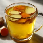 Close up of a full mug of golden bone broth turmeric ginger on stone surface