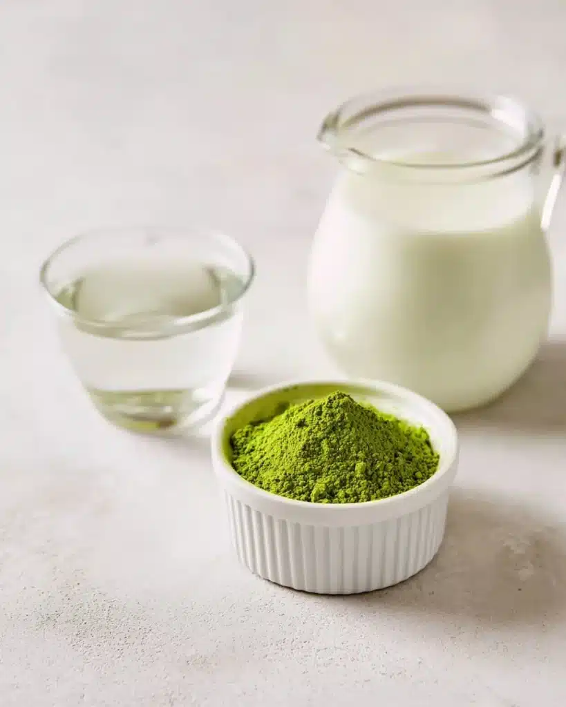 ingredients for Japanese green tea EGCG latte with matcha milk and water on a counter
