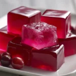 jelly burn recipe pink gelatin cubes on white ceramic plate with cranberry garnish