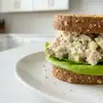 chick-fil-a chicken salad recipe on toasted wheat bread with butter lettuce on white ceramic plate
