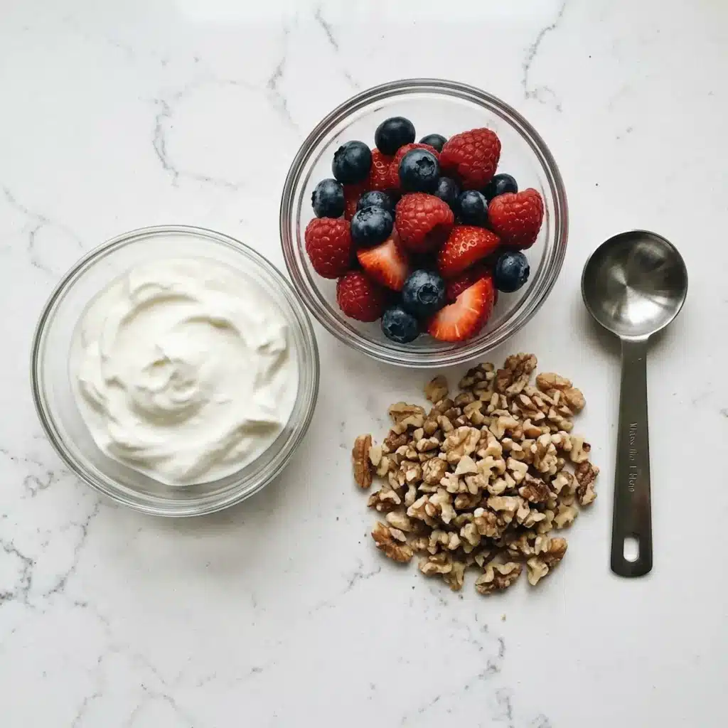 dr phil low sugar recipe ingredients flat lay greek yogurt fresh berries raw walnuts on white quartz counter
