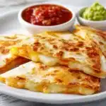 Crispy chicken quesadillas recipe with golden tortilla and melted cheese on white plate