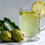 Soursop leaf tea in clear glass mug on white marble surface