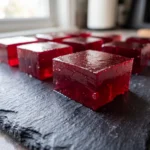 Authentic tart cherry gelatin recovery squares on a black slate.