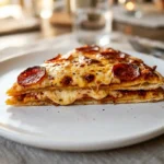 Sliced double decker tortilla pizza hack with crispy pepperoni on a white plate