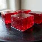 Authentic vegan jello made with agar agar on a black plate.