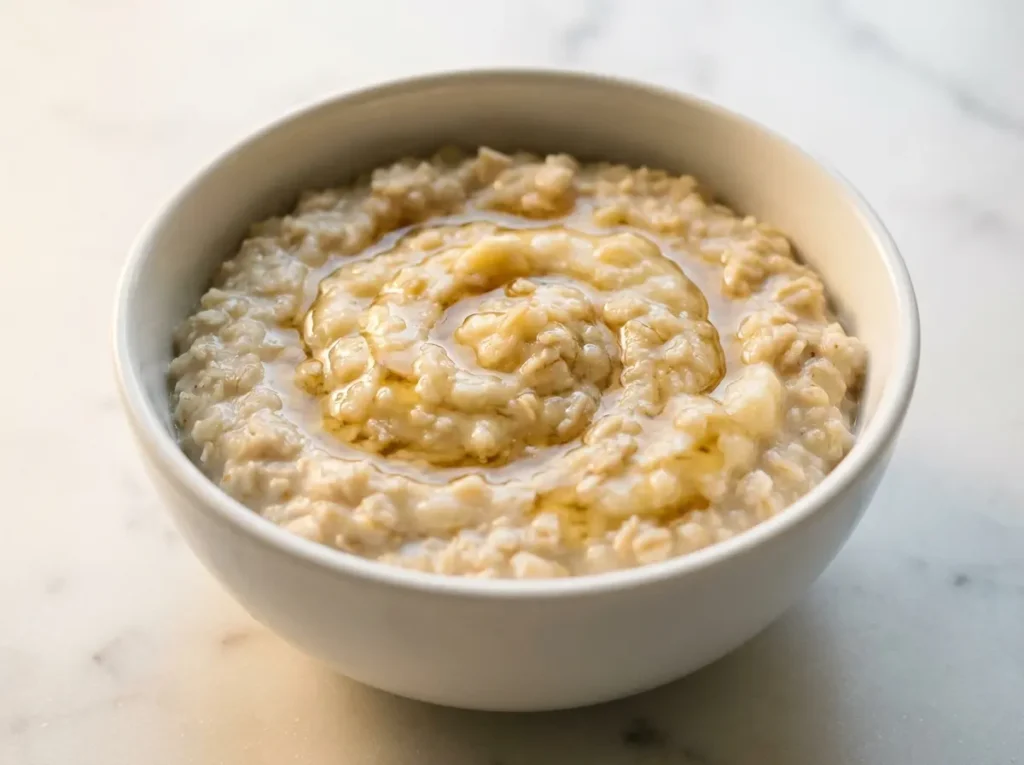 Easy to Digest Recipes for Wegovy Nausea: 7 Gentle Meals That Actually Work 4 Plain oatmeal with mashed banana and a drizzle of honey in a small white ceramic bowl on white marble
