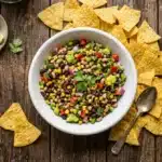 Cowboy caviar recipe served in a white bowl with tortilla chips