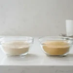 Two small glass bowls of gelatin powder side by side on a clean counter.